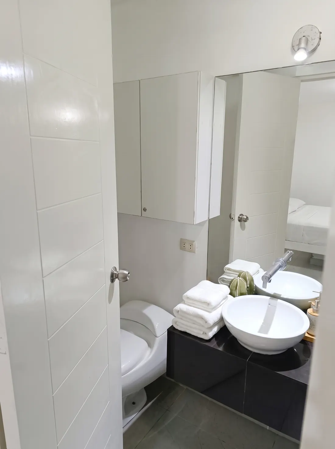 Baño del dormitorio principal con lavatorio de sobreponer y toallas blancas