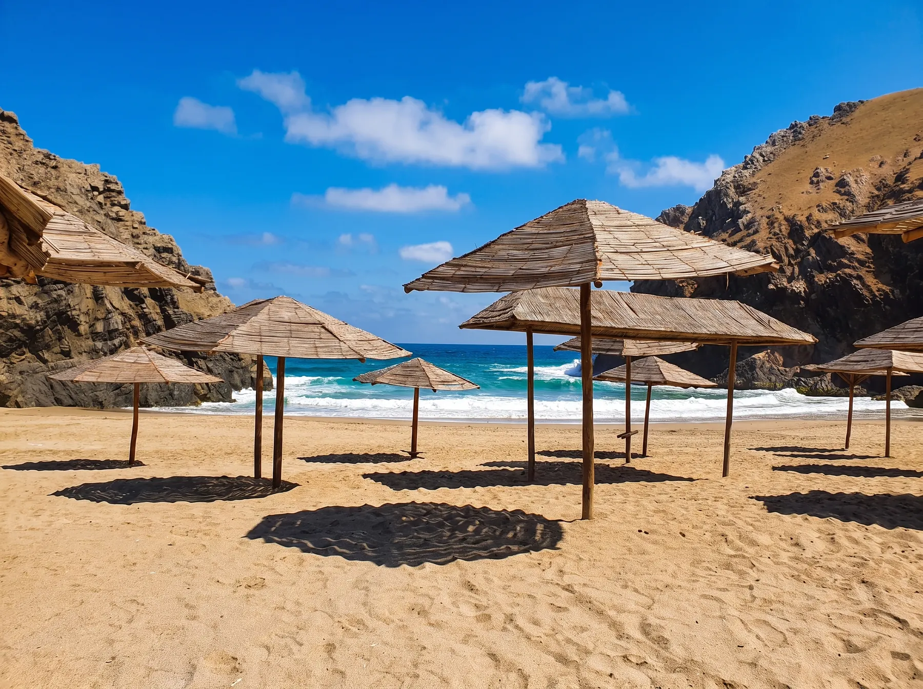 La caleta de día con sombrillas de junco y mar turquesa