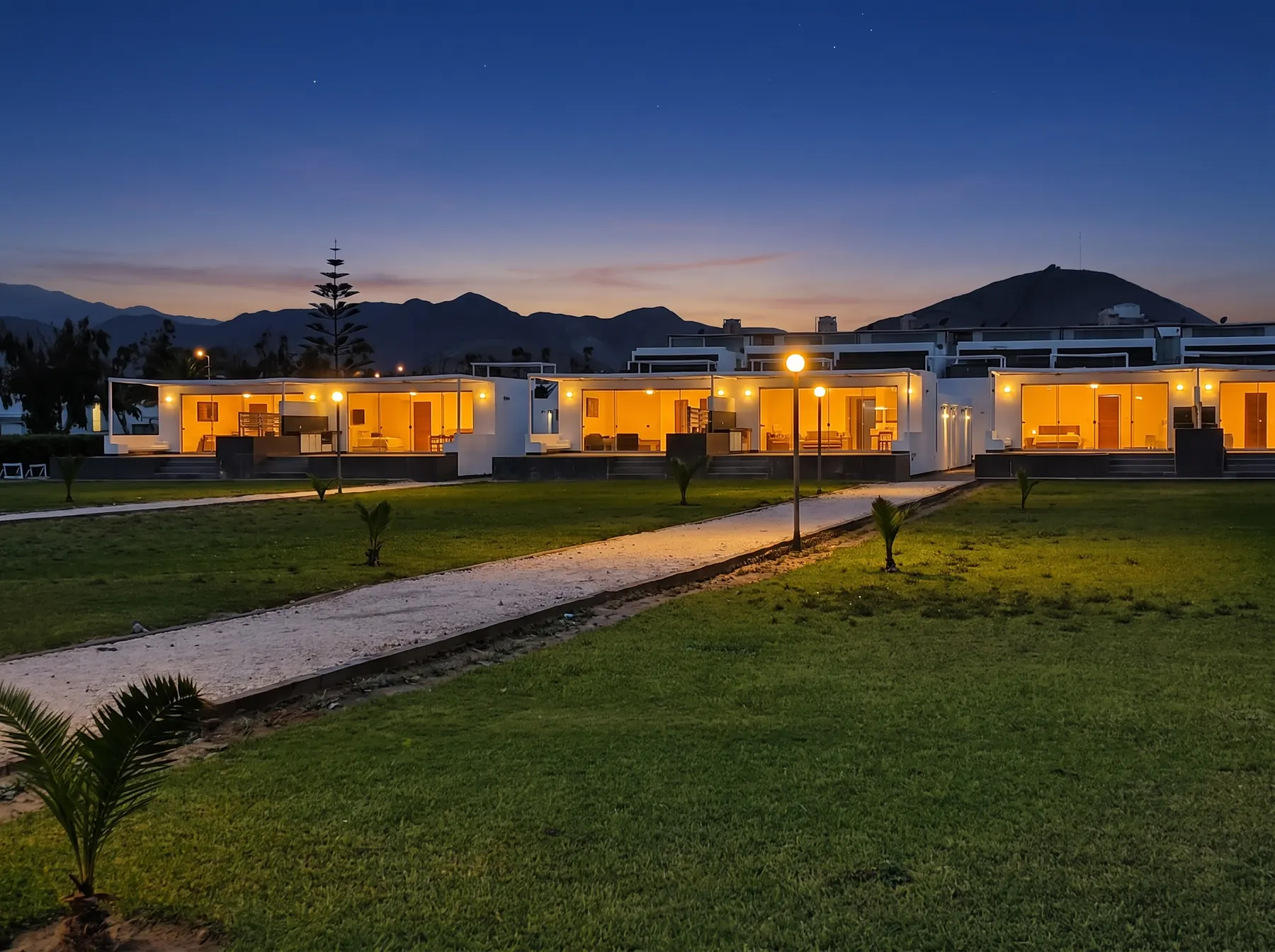 Condominio de noche con faroles encendidos a lo largo del camino
