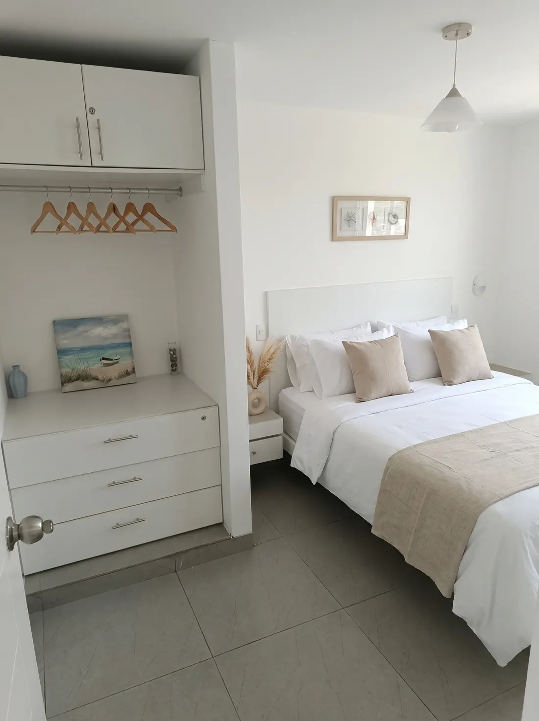 Dormitorio principal con cama Queen, ropa de cama blanca y clóset